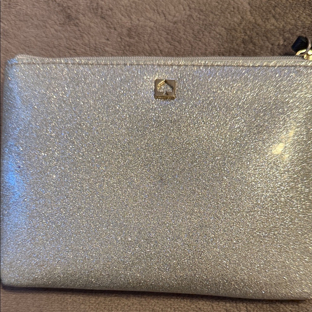 Kate Spade Sparkling Silver Pouch comes
with Kate Spade Pin